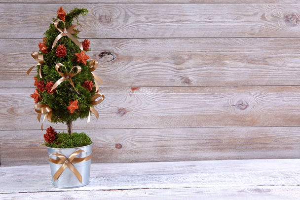 Albero di Natale decorativo in vaso su sfondo di legno beige
 - Foto, immagini