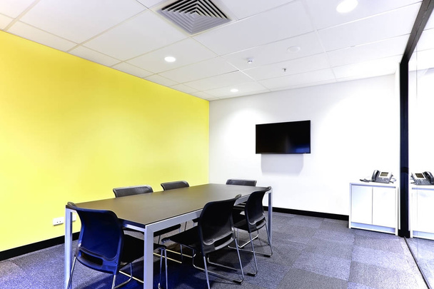 Conference room with black table and chairs covered walls - 写真・画像