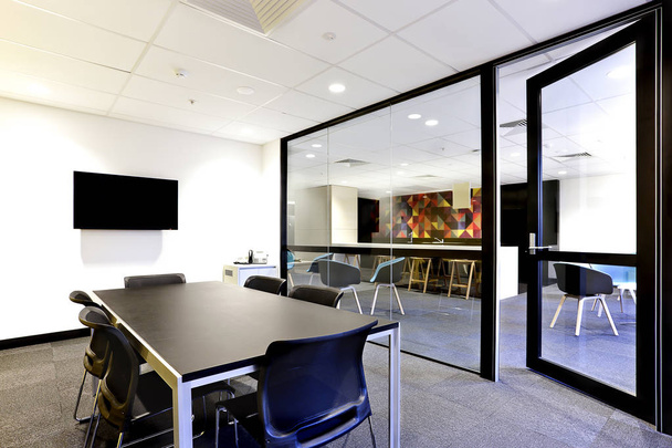 Conference room with black table with open glass door - Fotó, kép