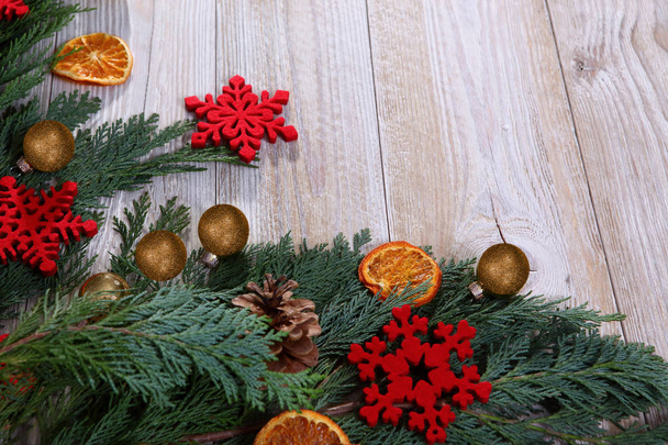 Χριστουγεννιάτικη σύνθεση με κλαδί χριστουγεννιάτικου δέντρου και αποξηραμένες φέτες πορτοκαλιού σε μπεζ ξύλινο φόντο - Φωτογραφία, εικόνα