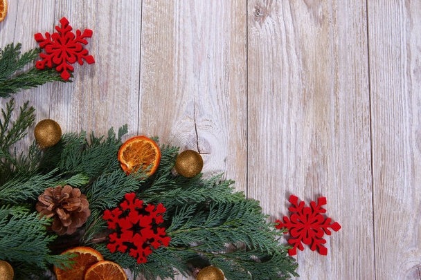 Composición navideña con rama de árbol de Navidad y rodajas de naranja secas sobre fondo de madera beige
 - Foto, Imagen
