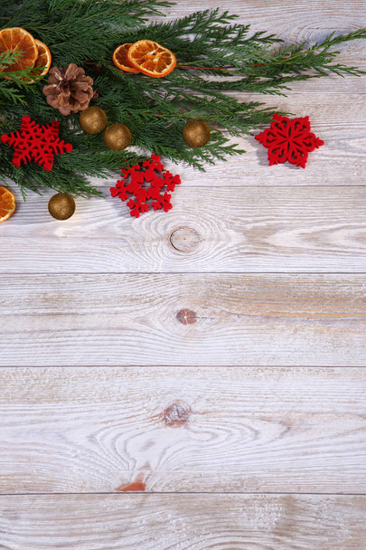 Composizione natalizia con ramo di albero di Natale e fette di arancio essiccate su sfondo beige in legno
 - Foto, immagini