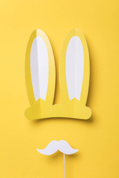 Yellow easter bunny ears with white moustache. Seasonal lay flat backgroud - Zdjęcie, obraz