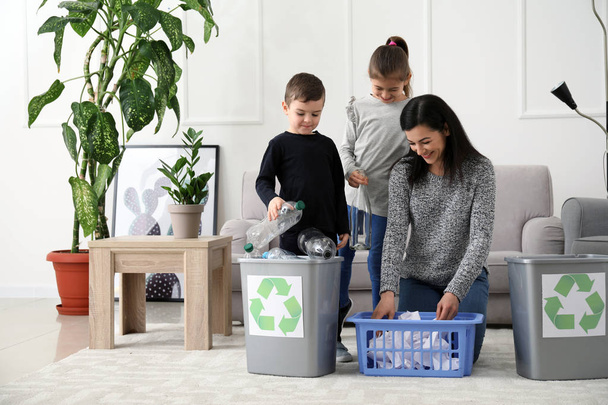 Perhe lajittelee roskia kotona. Kierrätyksen käsite
 - Valokuva, kuva
