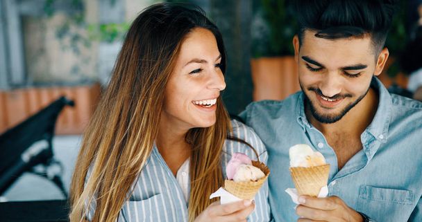 Happy νεαρό ζευγάρι έχει ημερομηνία και τρώγοντας παγωτό - Φωτογραφία, εικόνα