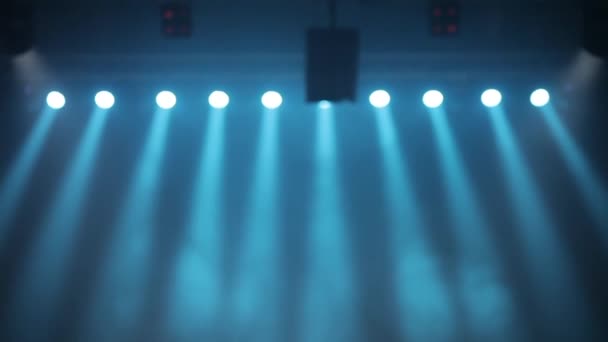 Lang shot van de scène, de fase light met gekleurde spotlights en rook. Blauwe spots in rook glans op het podium. - Video