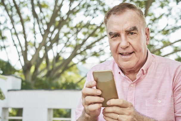 Portrait d'homme âgé heureux en utilisant l'application sur smartphone
 - Photo, image