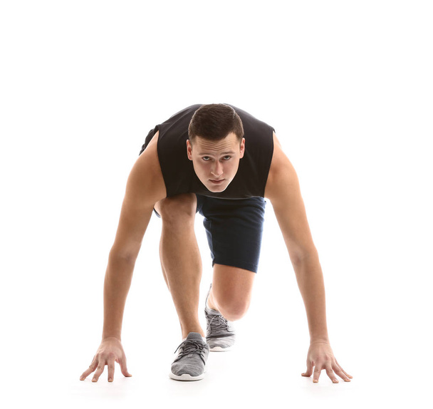 Sportos fiatalember crouch start helyzetben fehér háttér - Fotó, kép
