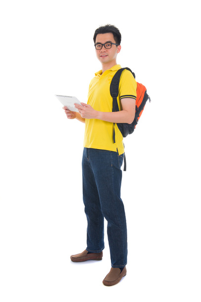 asian male student holding a tab and bag with isolated white bac - Фото, изображение