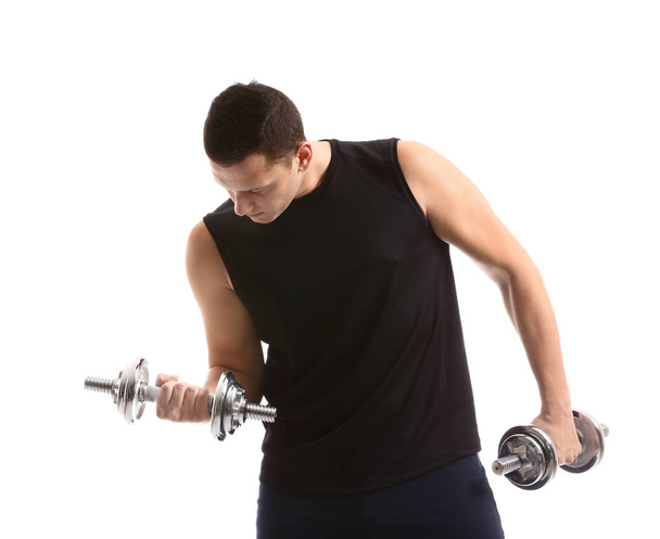 Sporty young man training with dumbbells against white background - Foto, immagini