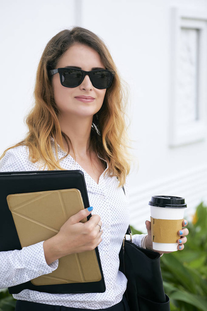 Glimlachen van elegante business lady bedrijf kopje koffie in de ochtend - Foto, afbeelding