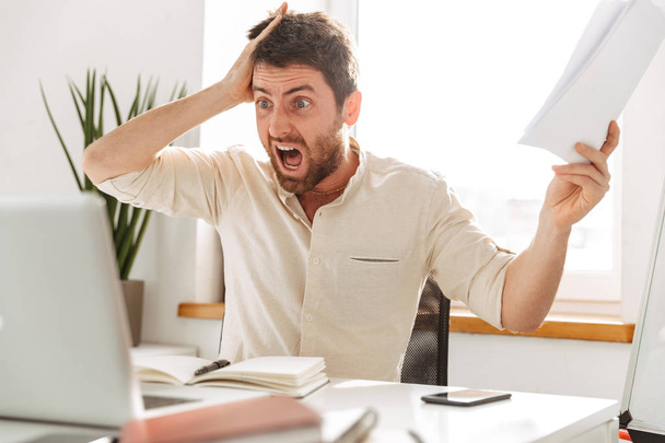 Image of shocked office worker 30s wearing white shirt, using la - Valokuva, kuva