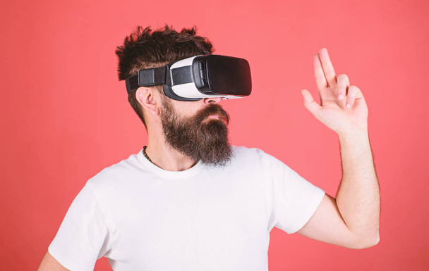 Best shooters for VR. First person shooter shows how addictive VR could be. Man hand gesture as gun play shooter game in VR glasses. Man bearded hipster with virtual reality headset on red background - Fotoğraf, Görsel