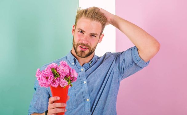 Macho holds bouquet as romantic gift. Guy bring romantic pleasant gift waiting for her. Man ready for date bring pink flowers. Boyfriend confident holds bouquet waiting for date. Best flowers for her - Photo, Image