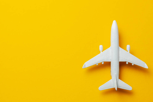 White passenger plane on yellow background. Copy space for text. - Photo, Image