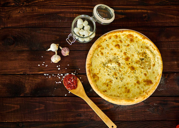 Delicious Italian pizza with cheese on a wooden table - Фото, зображення
