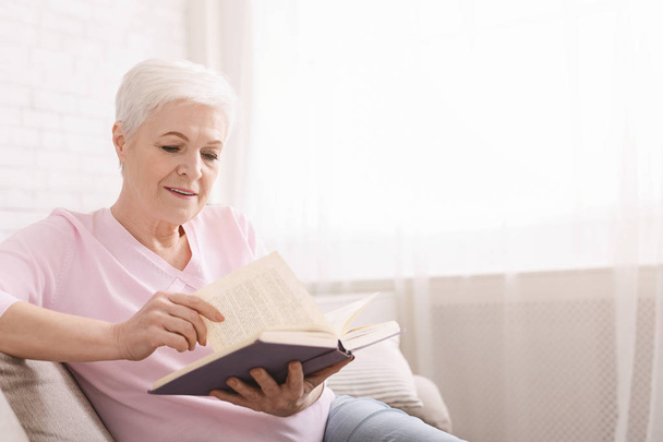 Mature woman reading business literature at home - Photo, Image