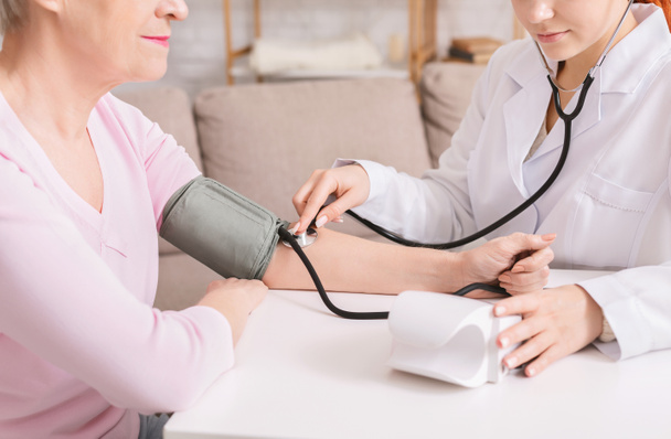 Arzt überprüft Blutdruck eines älteren Patienten - Foto, Bild