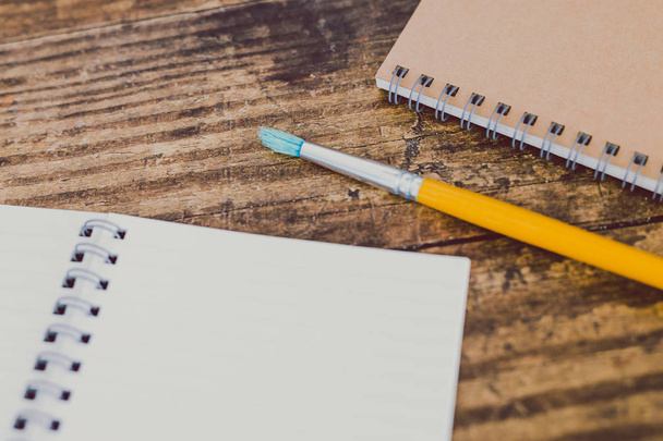 notebooks with brush on wooden desk - Foto, imagen