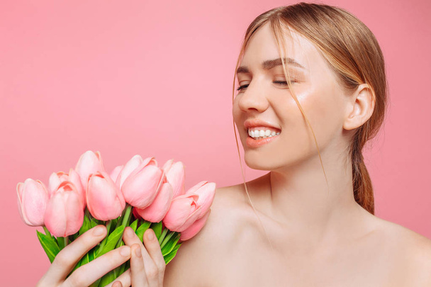 Beautiful young girl with clean skin holding a bouquet of pink t - Foto, Imagem