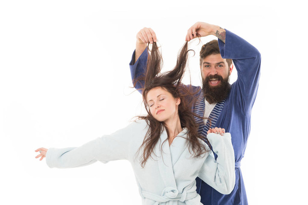 Good morning world. Go from flat to fluffy. happy bearded man play with hair of sleepy girl. family couple in robe. Love her hair. Hair health and care. I want to sleep. Morning sleepy couple - Photo, image