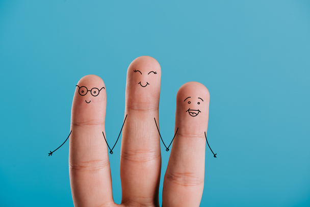vista recortada de dedos humanos felices tomados de las manos aisladas en azul
 - Foto, Imagen