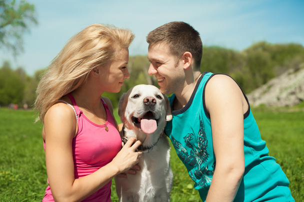 Young sports couple with a dog at the park - Photo, Image