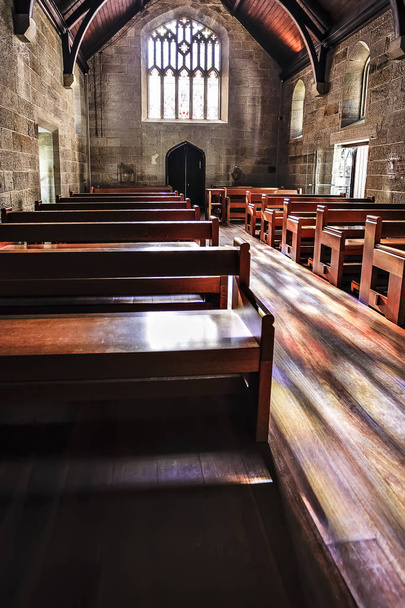 Wooden benches of an old stone church  - Foto, Imagen