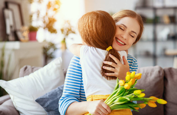 happy mother's day! child daughter   gives mother a bouquet of f - Foto, imagen