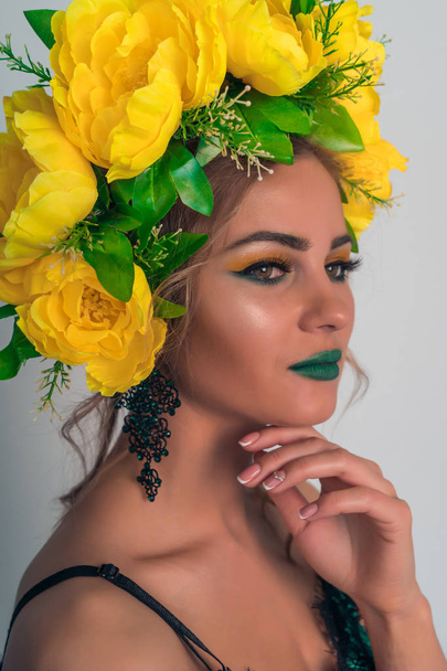 Portrait of a beautiful blonde with bright makeup and a rim of yellow flowers - Foto, immagini