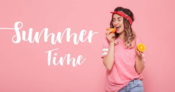 Напис Літній час. Красива молода дівчина в рожевій футболці, тримає смішний сексуальний апельсин на рожевому фоні
 - Фото, зображення