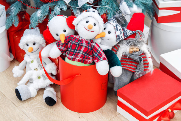 Gezellige winter vakantie achtergrond. Grappige speeltje sneeuwmannen en presenteert wachten op Kerstmis onder ingerichte fir boom. Vrolijke en magische sfeer van het nieuwe jaar vooravond, kopie ruimte - Foto, afbeelding