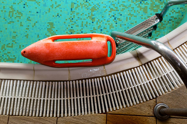 Red rescue buoy near the stairs in the swimming pool - Zdjęcie, obraz