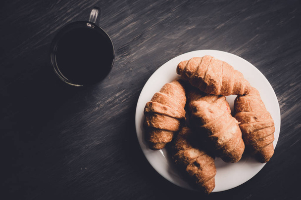 Makroschuss. Mate launische Farbe. Kaffee und frische Croissants auf schwarzem Hintergrund. Dessert und Kaffee. das Konzept des Frühstücks. - Foto, Bild