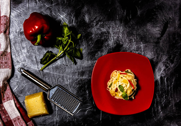 Pasta over red dish and other ingredients - 写真・画像
