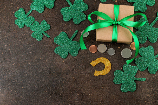 St.Patrick barátait nap. ünnepe. Csokornyakkendő, patkó, díszdobozok és a barna háttér lóhere. Nézd meg felülről. hely a szöveg - Fotó, kép