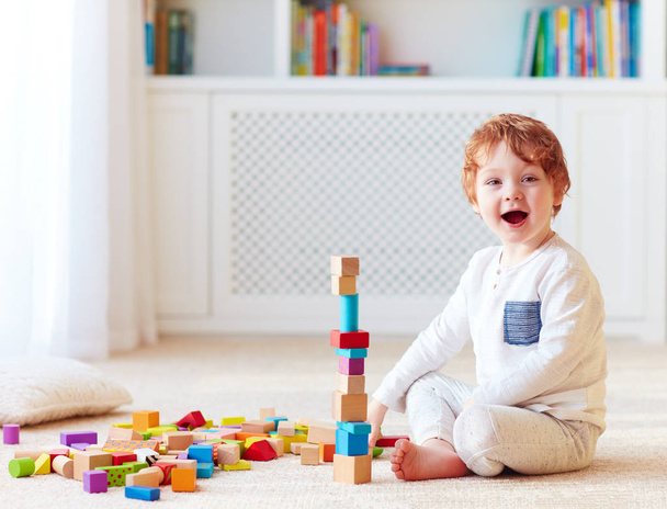 cute toddler baby boy playing with wooden blocks, building a high tower - Foto, afbeelding