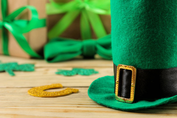 Día de San Patricio. celebración. Sombrero de duende verde, herradura y hojas de trébol sobre un fondo de madera natural. primer plano
 - Foto, imagen