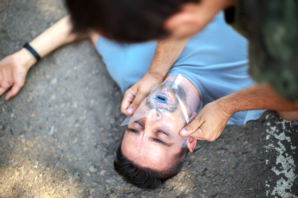 Człowiek pierwszej pomocy osobie za pomocą handkerch Zbawiciela - Zdjęcie, obraz