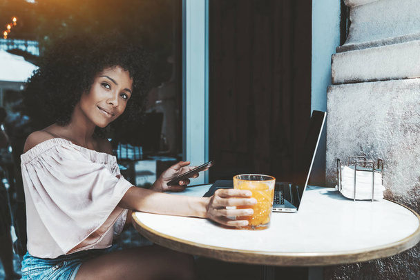 Afro girl in street bar with gadgets - Zdjęcie, obraz
