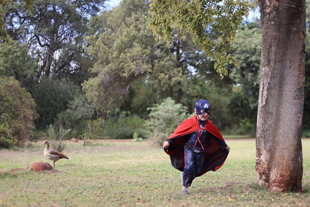 chłopiec w park z Kapitan Ameryka strój superbohatera grać - Zdjęcie, obraz