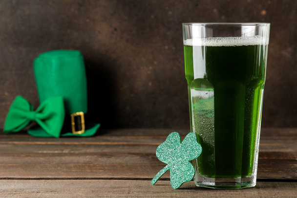 St.Patrick 's Day. celebration. green beer, leprechaun hat, coins, bow tie and clover on a brown background. - 写真・画像