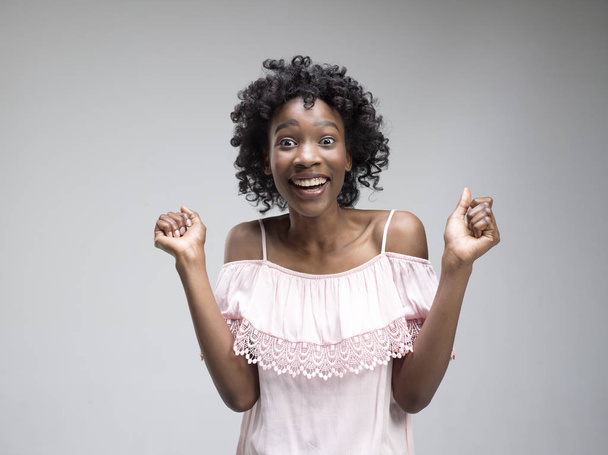 Winning success woman happy ecstatic celebrating being a winner. Dynamic energetic image of female afro model - Valokuva, kuva