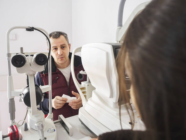 Ο άνθρωπος μιλά για τον οφθαλμίατρο κατά τη διάρκεια μιας εξετάσεις μάτια με σκίσιμο L - Φωτογραφία, εικόνα