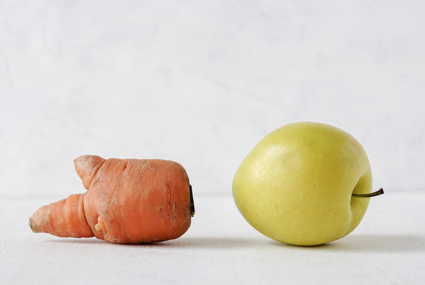 Παραμορφωμένο χρυσό μήλο και καρότο σε λευκό - Φωτογραφία, εικόνα