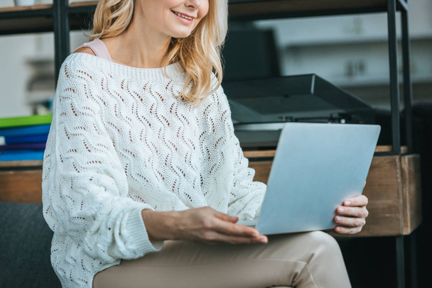 vista ritagliata donna felice sorridente mentre guardando il computer portatile a casa
 - Foto, immagini