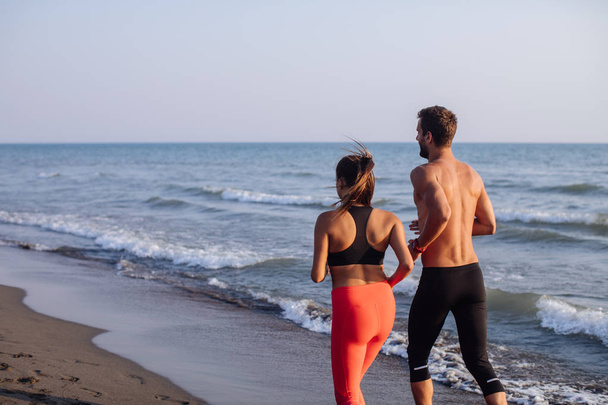 Couple Jogging by the Sea - Photo, image