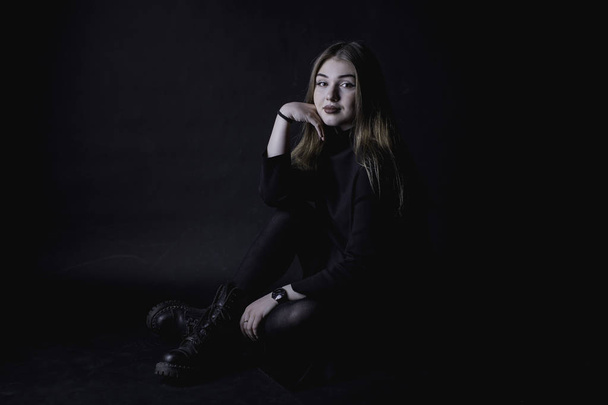 young girl in a black dress on a dark background in the studio - Photo, image