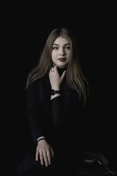 young girl in a black dress on a dark background in the studio - Fotografie, Obrázek