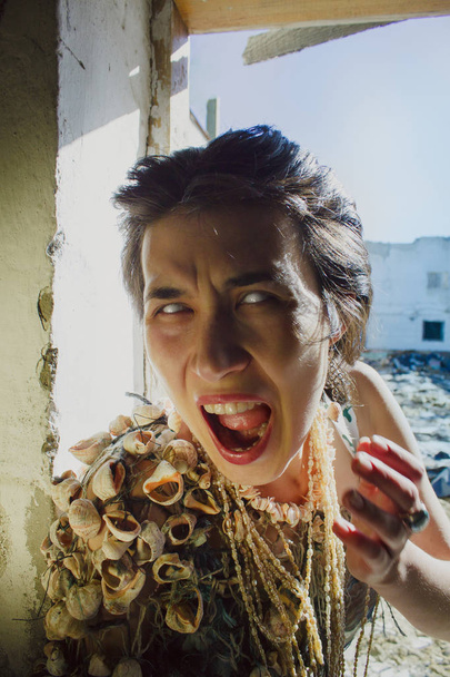 Post apocalyptic girl with seashells on her shoulder crying - Φωτογραφία, εικόνα